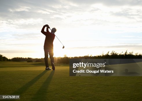 Senior golfer teeing off on golf course. Senior golfer teeing off on golf course.
