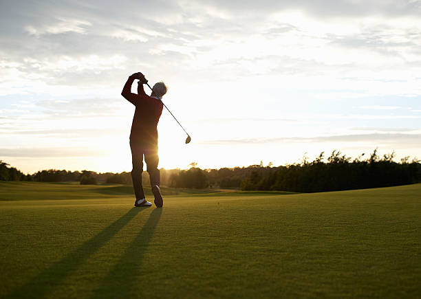 senior golfer teeing off on golf course. - golf stock pictures, royalty-free photos & images