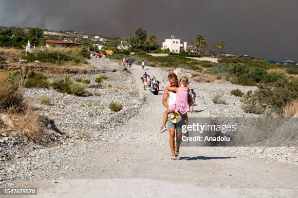 Tourists are evacuated as huge wildfire rages across Greece's Rhodes island on July 22, 2023. Thousands of tourists were evacuated from hotels on the...