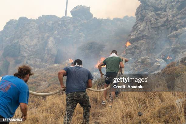 Firefighter teams intervene a wildfire across Greece's Rhodes island on July 22, 2023. Thousands of tourists were evacuated from hotels on the...