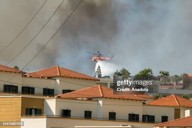 Firefighter helicopter drops water as teams conduct extinguishing works by land and air to control wildfires across Greece's Rhodes island on July...