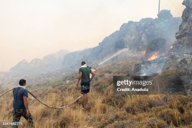 Firefighter teams intervene a wildfire across Greece's Rhodes island on July 22, 2023. Thousands of tourists were evacuated from hotels on the...