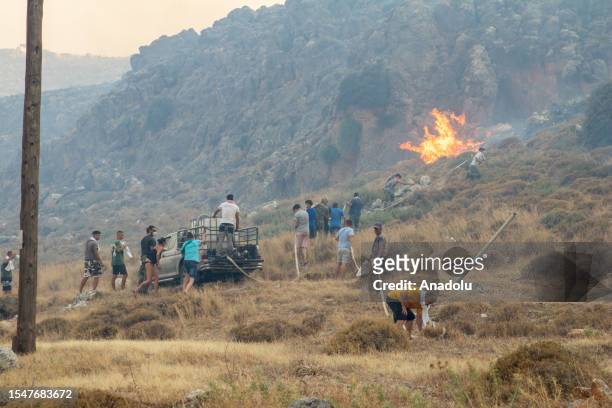 Firefighter teams intervene a wildfire across Greece's Rhodes island on July 22, 2023. Thousands of tourists were evacuated from hotels on the...