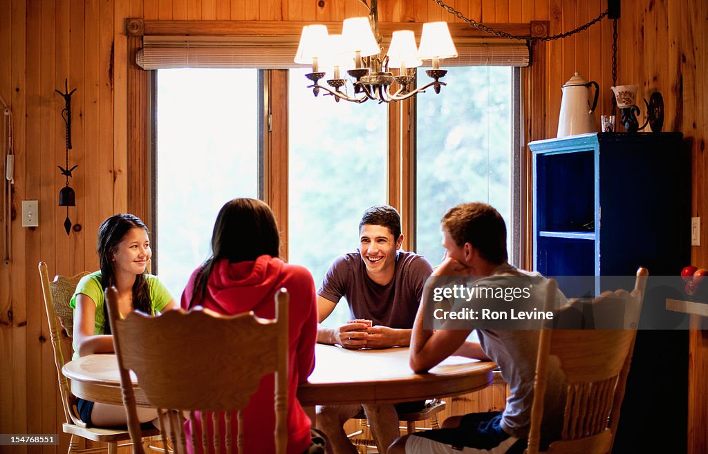 Teens playing a card game at a cottage