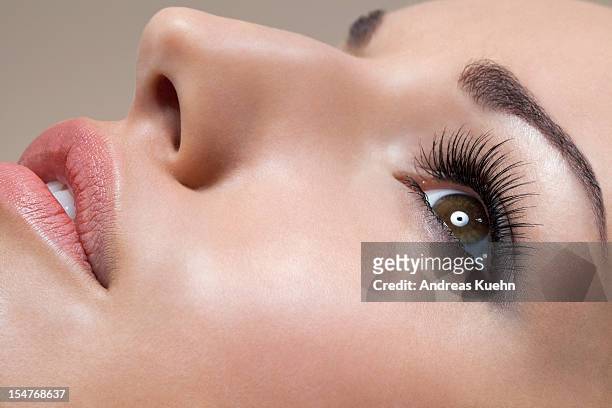 side view of young woman laying down, close up. - eyelash photos et images de collection