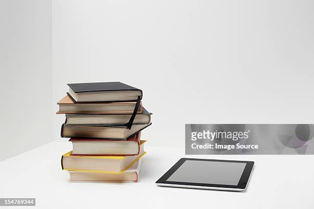 stack of books with digital tablet - stack of books stock pictures, royalty-free photos & images