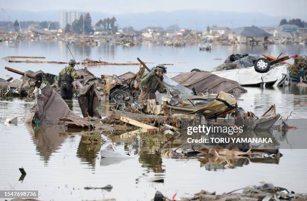 Japanese Self-Defence Force soldiers look for victims amid the debris left by the March 11 tsunami and earthquake in Natori in Miyagi Prefecture on...