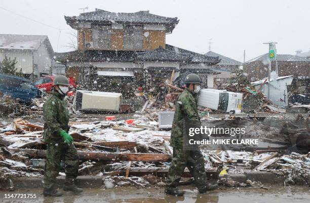 Japanese soldiers make their way across a sea of devastation and debris in Natori, Miyagi prefecture on March 16, 2011 after the March 11 earthquake...