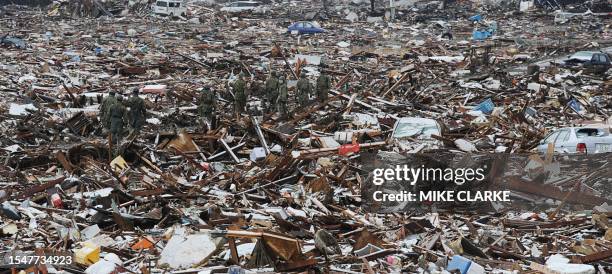 Japanese soldiers make their way across a sea of devastation and debris in Natori, Miyagi prefecture on March 16, 2011 after the March 11 earthquake...