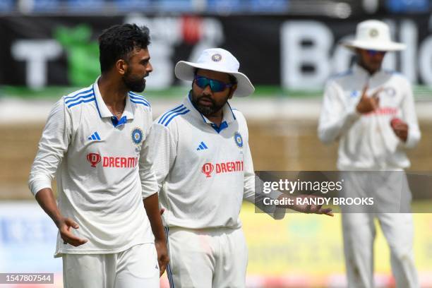 Jaydev Unadkat and Rohit Sharma of India make plans during the third day of the second Test cricket match between India and West Indies at Queen's...