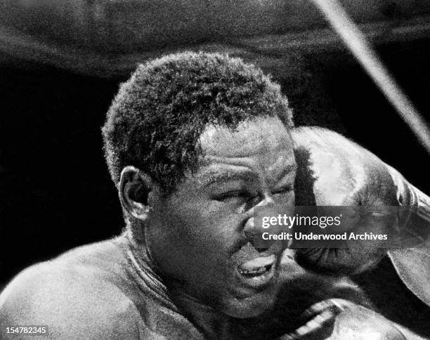 Rocky Marciano launches a right fist to the left side of Ezzard Charles face in the sixth round of their heavyweight title bout in Yankee Stadium....