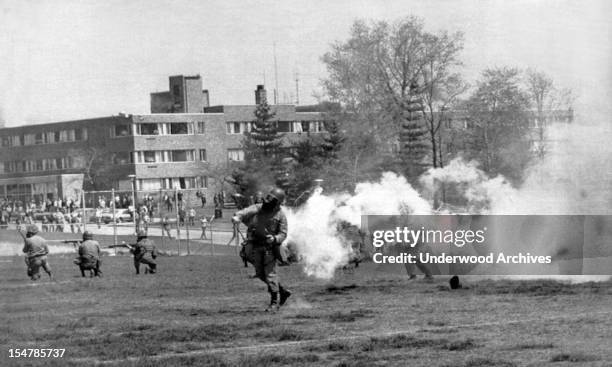 National Guard troops throw tear gas into the rioters at Kent State protesting the American invasion of Cambodia. Shortly after the troops opened...