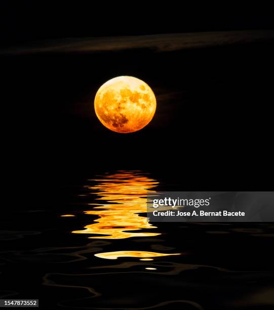 full frame of the full moon in the sky reflected on a water surface. - lac reflection lake photos et images de collection