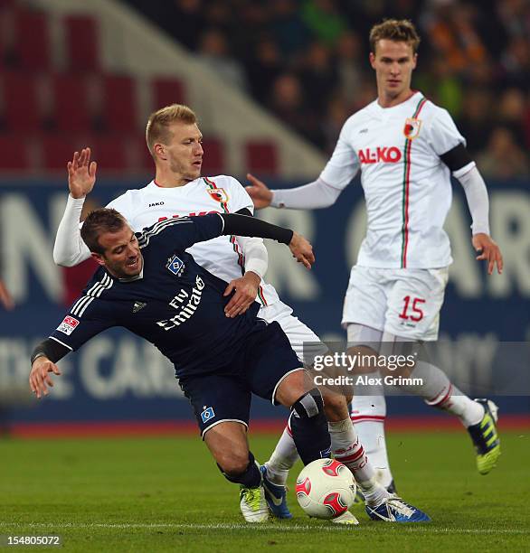 Rafael van der Vaart of Hamburg is challenged by Kevin Vogt and Sebastian Langkamp of Augsburg during the Bundesliga match between FC Augsburg and...