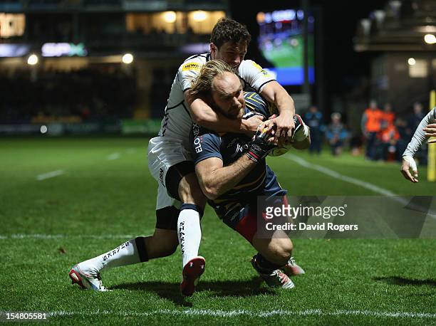 Andy Goode of Worcester dives over for a try despite being held by Tom Brady during the Aviva Premiership match between Worcester Warriors and Sale...
