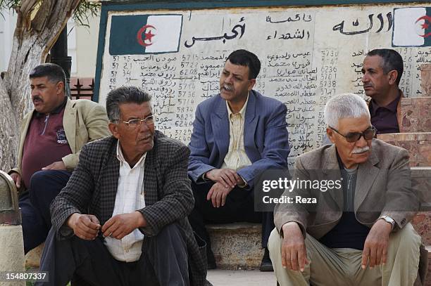 Elderly men gather in the town hall square on April 14 in El Malah, Algeria, at a monument dedicated to the martyrs who died during the Algerian war .