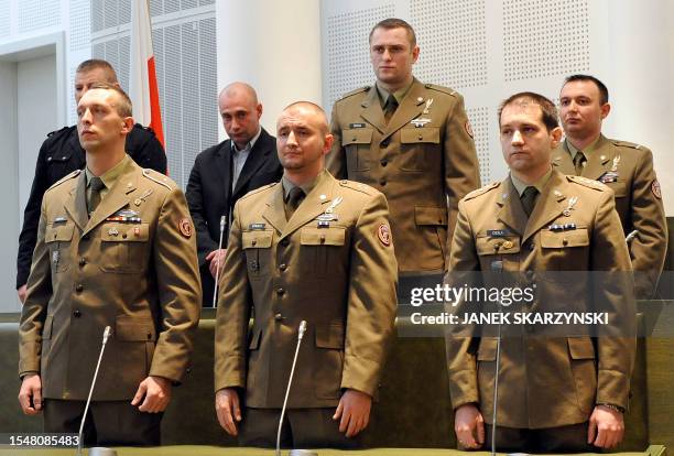 Polish soldiers stand in court as they listen to judge Wieslaw Blus who overturned the acquittal on four of the seven troops charged with having...