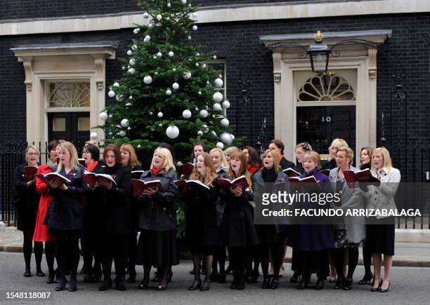 Military wives' sing outside number 10 Downing Street to welcome British service personnel arriving for a reception with British Prime Minister David...
