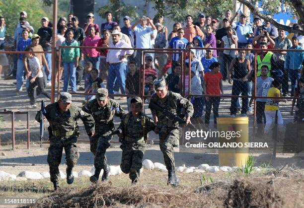 Relatives of inmates awaiting outside the perimeter fence throw stones at soldiers and policemen on guard at the National Prison compound in...