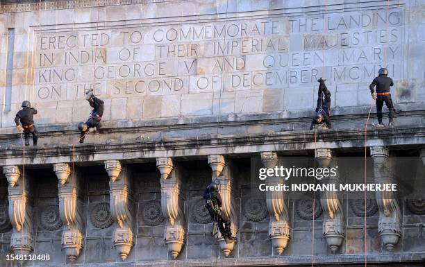 Indian naval commandos abseil from the iconic Gateway of India as they take part in a demonstration drill in Mumbai on December 2, 2011. India...