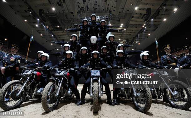 Soldiers from the British Army Royal Signals White Helmets display team pose on motorbikes during a media preview at Earl's Court in central London...