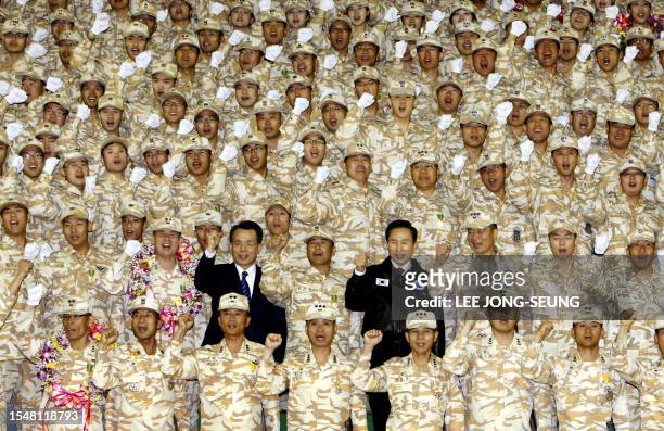 South Korean President Lee Myung-Bak and Prime Minister Han Seung-Soo pose with soldiers during the disbandment ceremony of South Korean contingent...