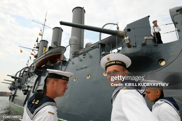 Russian Navy sailors stand in front of the Aurora cruiser, built in 1900, now a museum and one of the St. Petersburg's landmarks, during a Navy Day...