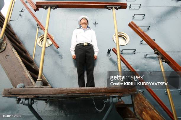 Russian Navy sailor stands on gangway of a military ship during a Navy Day parade rehearsal on Neva River in St. Petersburg, on July 29, 2011. The...