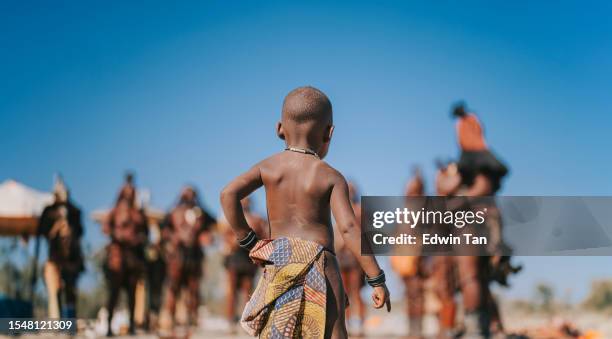 rear view namibian himba child looking at villagers - african tribal culture 個照片及圖片檔