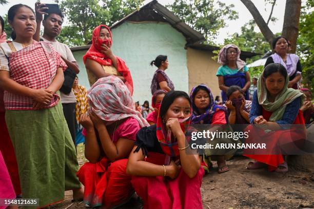 In this photo taken on July 22, 2023 a group of Meira Paibi women of the Meiti community gather in front of the partially charred house of an alleged...