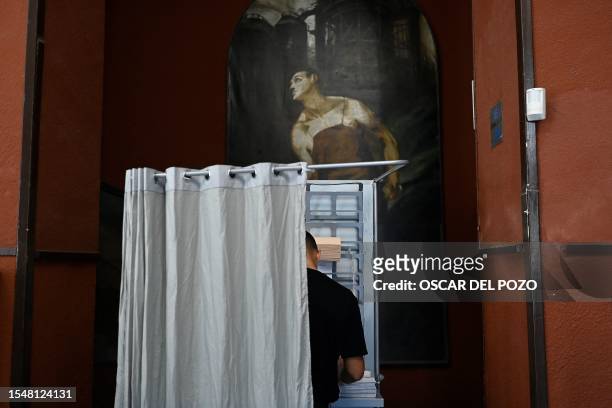 Person votes in a booth at the Rios Rosas polling station in Madrid, during Spain's general election on July 23, 2023. Spain votes today on whether...