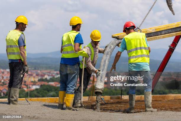 construction workers, pouring concrete with a pipe into the armature - builders boots stock pictures, royalty-free photos & images