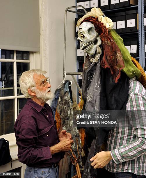 Director and artist Ralph Lee helps an actor in his costume backstage before "The Grand Procession of the Ghouls" at the Halloween Extravaganza and...