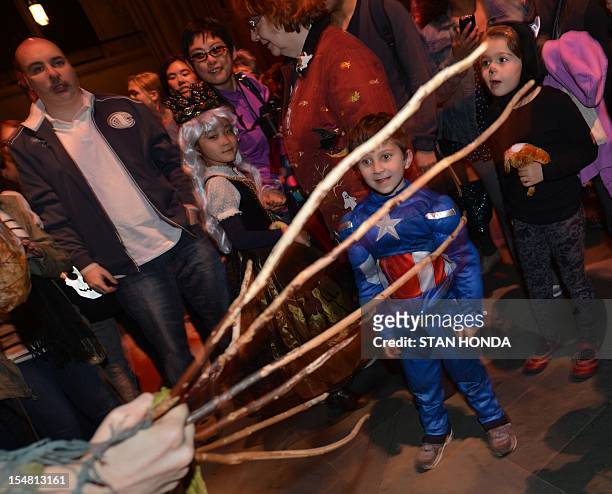 Children look at a creature after "The Grand Procession of the Ghouls" at the Halloween Extravaganza and Procession of the Ghouls October 26, 2012 at...