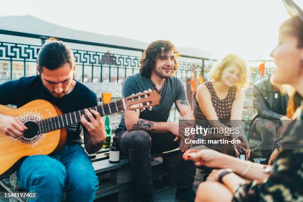 friends drinking and partying on the rooftop - singles stock pictures, royalty-free photos & images