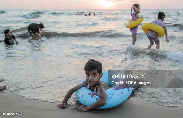 Palestinian children play at the beach before sunset in Gaza City.
