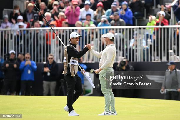 Rory McIlroy of Northern Ireland celebrates with his caddie Harry Diamond after putting in to win the tournament on the 18th green during Day Four of...
