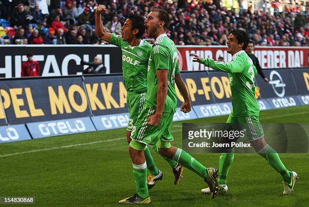 Bas Dost of Wolfsburg celebrates with his team mates Fagner and Makoto Hasebe after scoring his team's third goal during the Bundesliga match between...