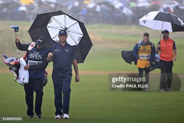 Golfer Gary Woodland and England's Brandon Robinson Thompson walk up the 18th fairway on day four of the 151st British Open Golf Championship at...