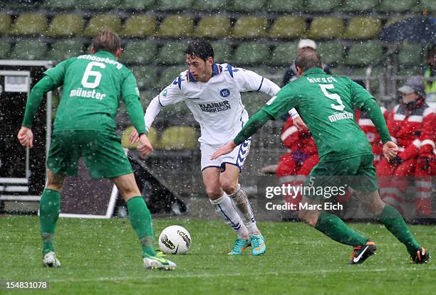 Kevin Schoeneberg of Muenster and Patrick Kirsch of Muenster challenge Hakan Calhanoglu of Karlsruhe during the third league match between Karlsruher...