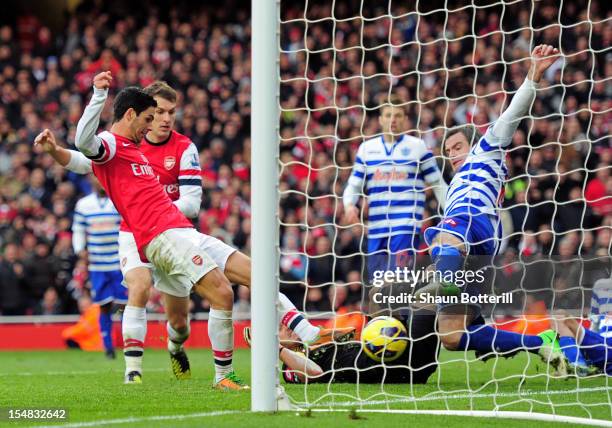 Mikel Arteta of Arsenal pokes the ball past Ryan Nelsen of QPR to score the opening goal during the Barclays Premier League match between Arsenal and...