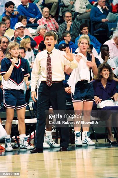 Italian-born American women's basketball coach Geno Auriemma, of the University of Connecticut, raises his hand to protest a call during a game,...