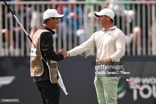 Rory McIlroy of Northern Ireland celebrates with his caddie Harry Diamond after putting in to win the tournament on the 18th green during Day Four of...