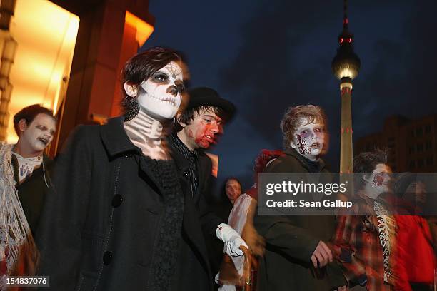 Zombie enthiusiasts walk past the broadcast tower at Alexanderplatz during a "Zombie Walk" in the city center on October 27, 2012 in Berlin, Germany....