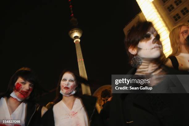 Zombie enthiusiasts walk past the broadcast tower at Alexanderplatz during a "Zombie Walk" in the city center on October 27, 2012 in Berlin, Germany....