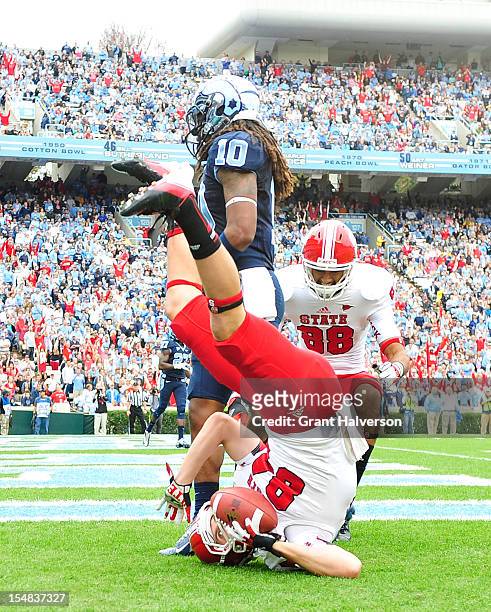 Charlie Hegedus of the North Carolina State Wolfpack makes an acrobatic touchdown catch against Tre Boston of the North Carolina Tar Heels during...