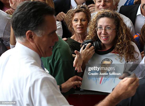 Supporter holds a picture of Republican presidential candidate, former Massachusetts Gov. Mitt Romney during a campaign rally at Ranger Jet Center on...