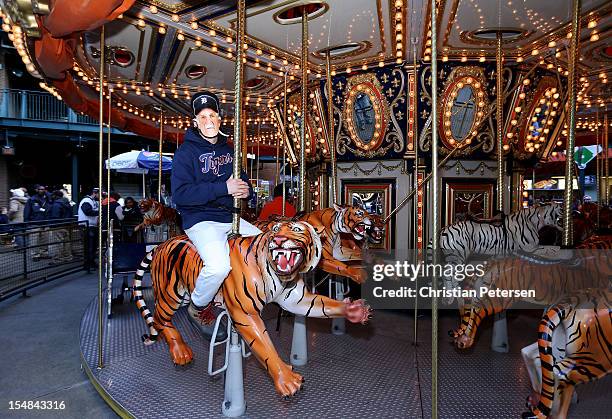 Fan of the Detroit Tigers wears a mask with the likeness of Tigers' manager Jim Leyland as he rides a carousel at the ballpark prior to the Tigers...