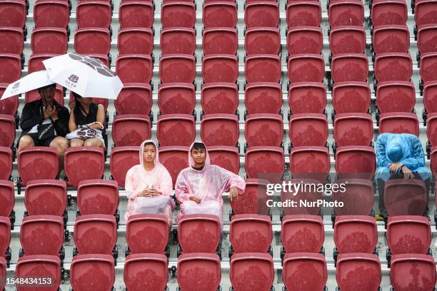 Supporters wear ponchos and use umbrellas to shield the rain as the preseason friendly match between Tottenham Hotspur and Leicester City is...