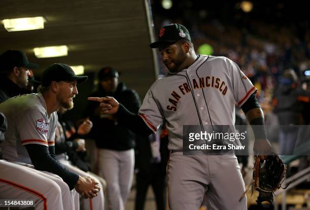 Pablo Sandoval of the San Francisco Giants talks with teammate Hunter Pence in the dugout prior to Game Three of the Major League Baseball World...